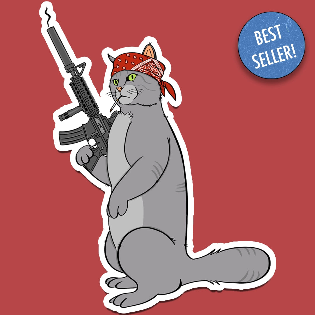 Sticker of a cat wearing a bandana and resting a large rifle on his shoulder, illustrated in a tough, cartoon style.
