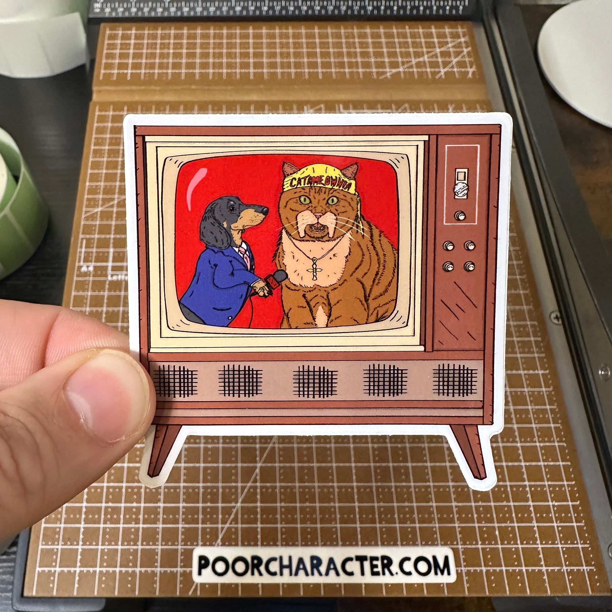 Sticker of A vintage console TV showing an interview with the Catamaniac and 'Mean Ween' Okerlund