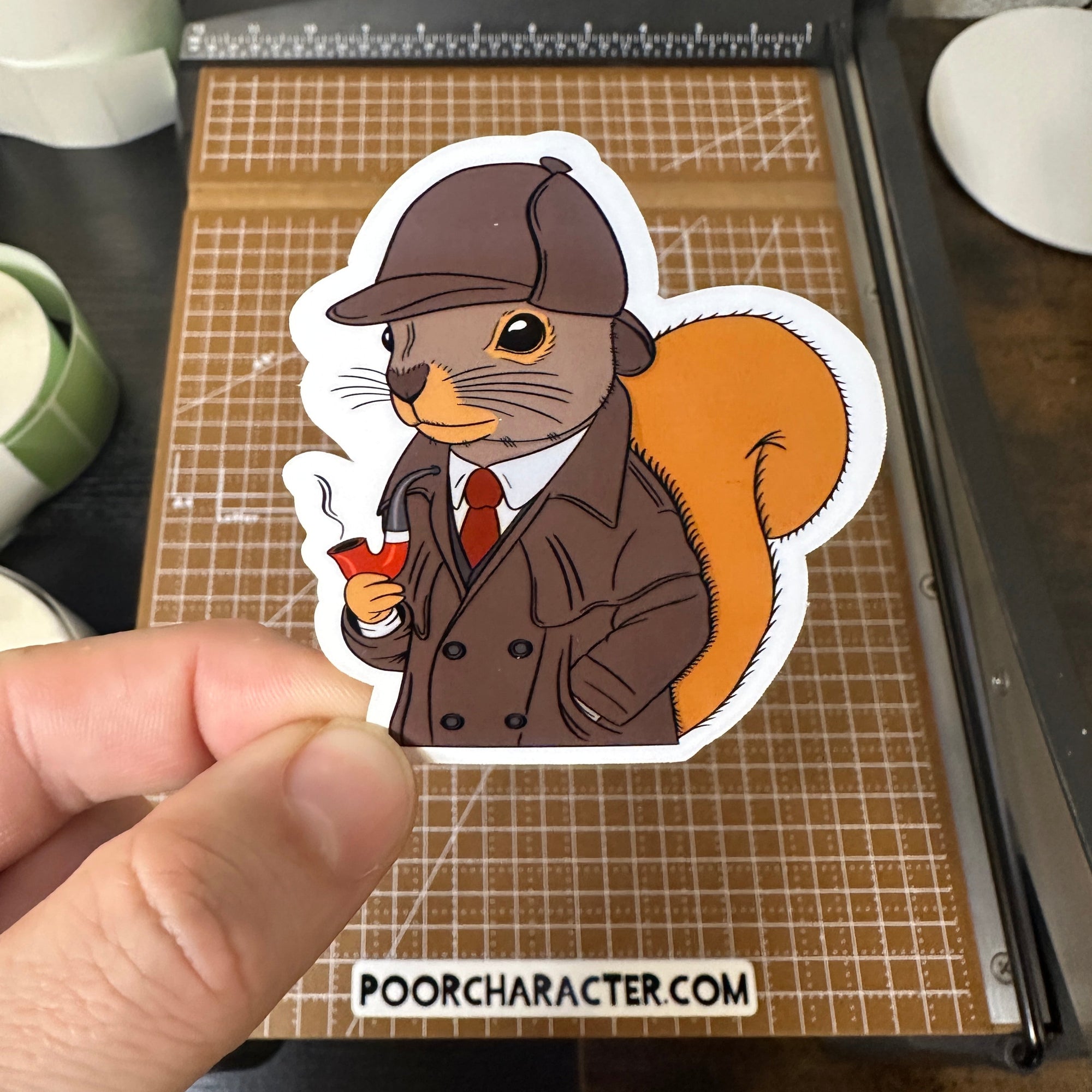 Sticker of A squirrel dressed like Sherlock Holmes, holding a pipe